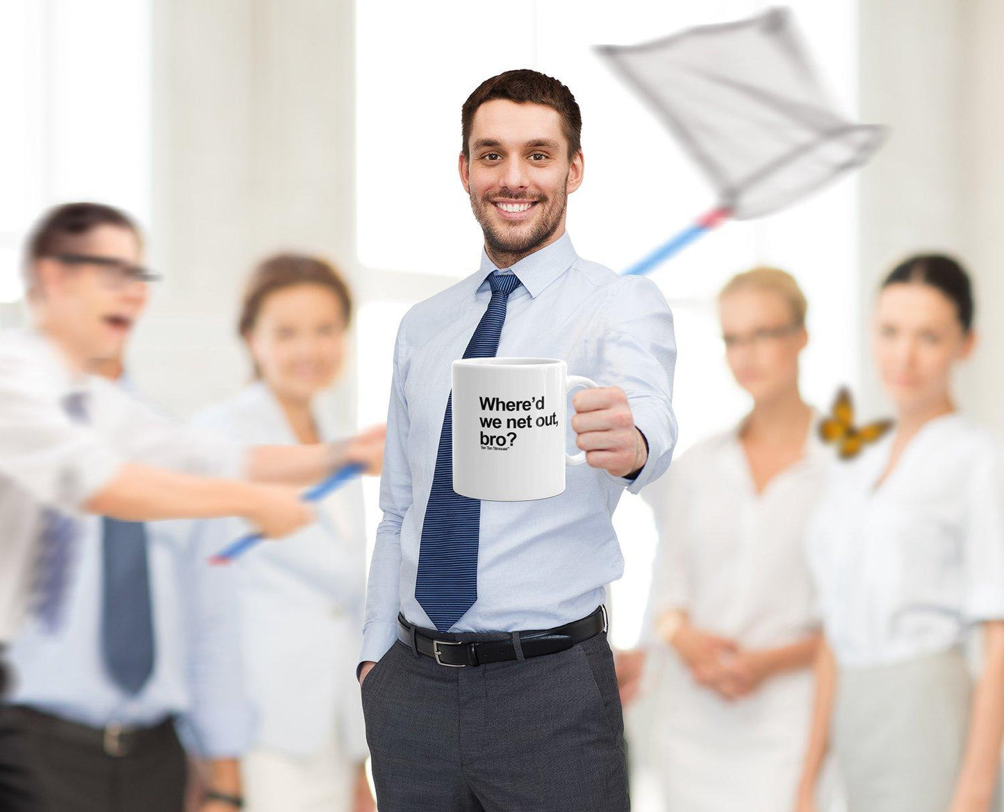 stock photo office setting, guy holding mug that says "Where'd we net out, bro?" with guy in background chasing butterfly with big net