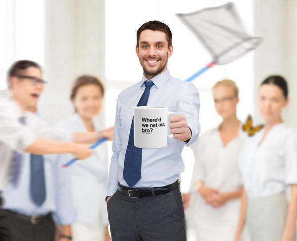 stock photo office setting, guy holding mug that says "Where'd we net out, bro?" with guy in background chasing butterfly with big net