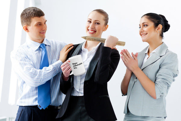 funny office mug: major stakeholder, bro - stock photo of business woman holding mug and made to look like she is holding a wooden steak and ready to stab coworker